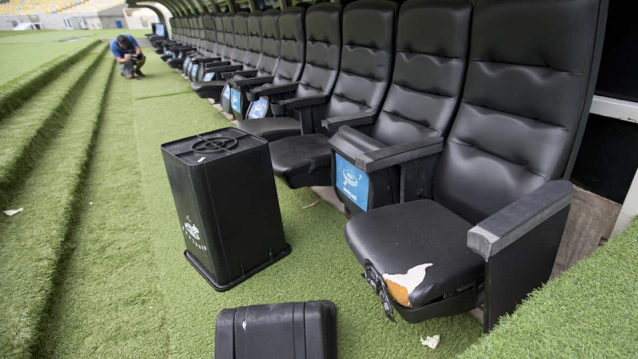 A trash can lays by ripped seats in Maracana stadium