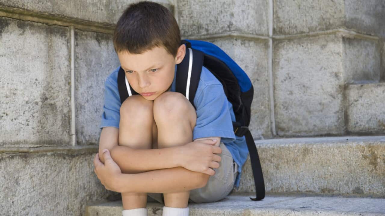 Little boy hugging his knees in desperation