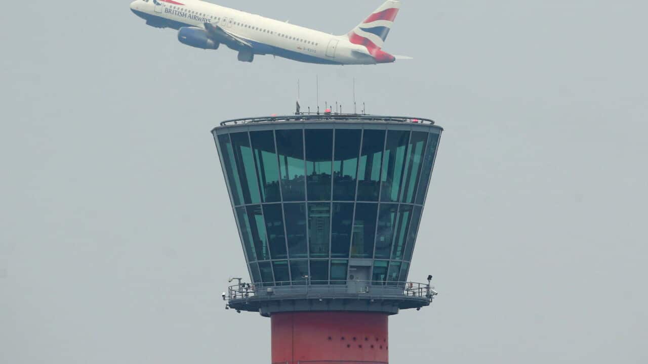 A British Airways plane takes off above the control tower at Heathrow Airport