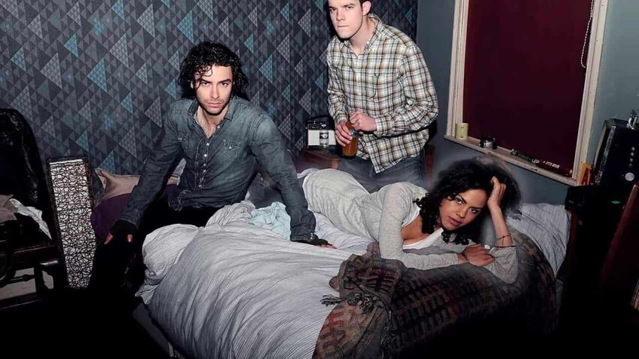 Two men and one woman relax on a bed together in their share house.jpeg