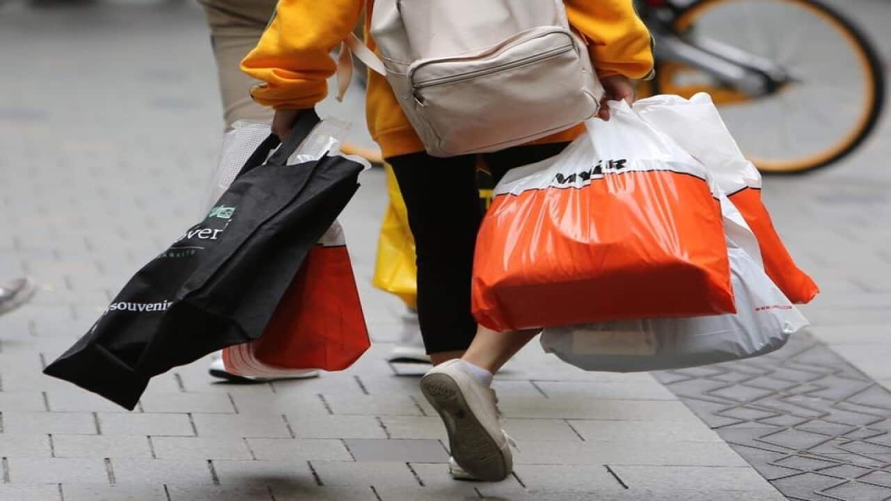 A shopper is seen carrying shopping bags.