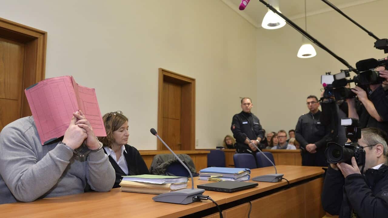 Niels Hoegela has been accused of multiple murder and attempted murder of patients is seen here in 2015 covering his face at the district court in Oldenburg.