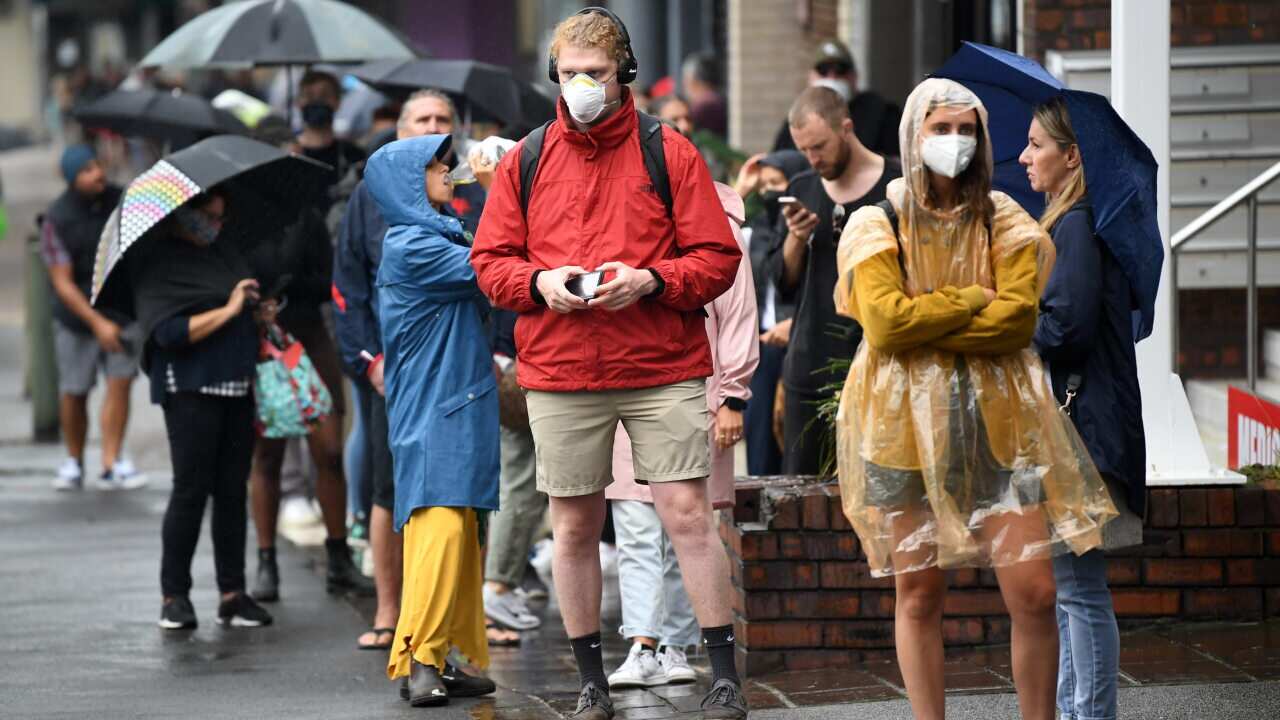 People are seen queuing outside a Centrelink office in Bondi Junction, Sydney.