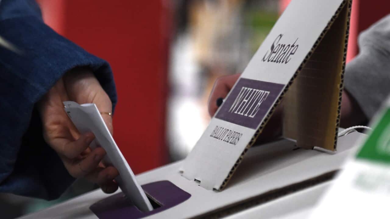 Voters cast their ballot during the federal election