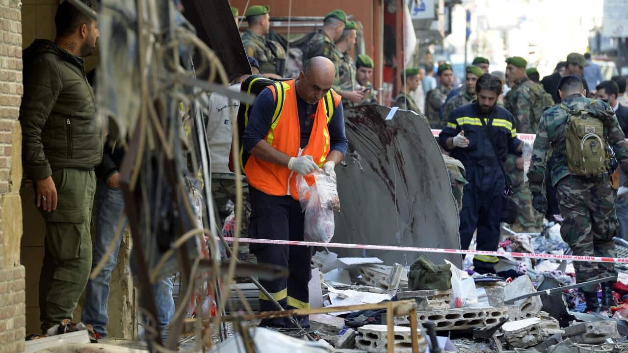 Members of the Lebanese police forces and Hezbollah inspect the site of a twin suicide attack in the Bourj al-Barajneh suburb of Beirut. (EPA)