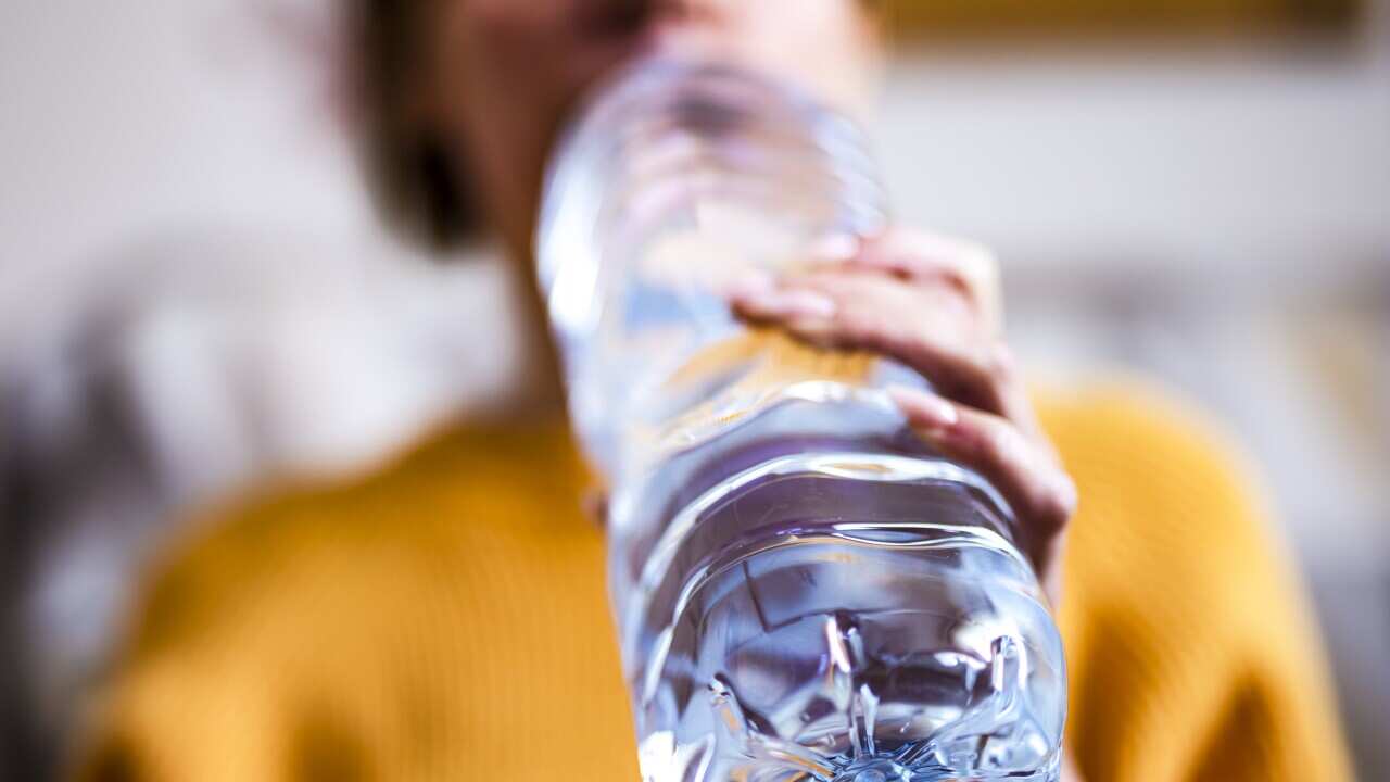 Woman drinking mineral water from the bottle