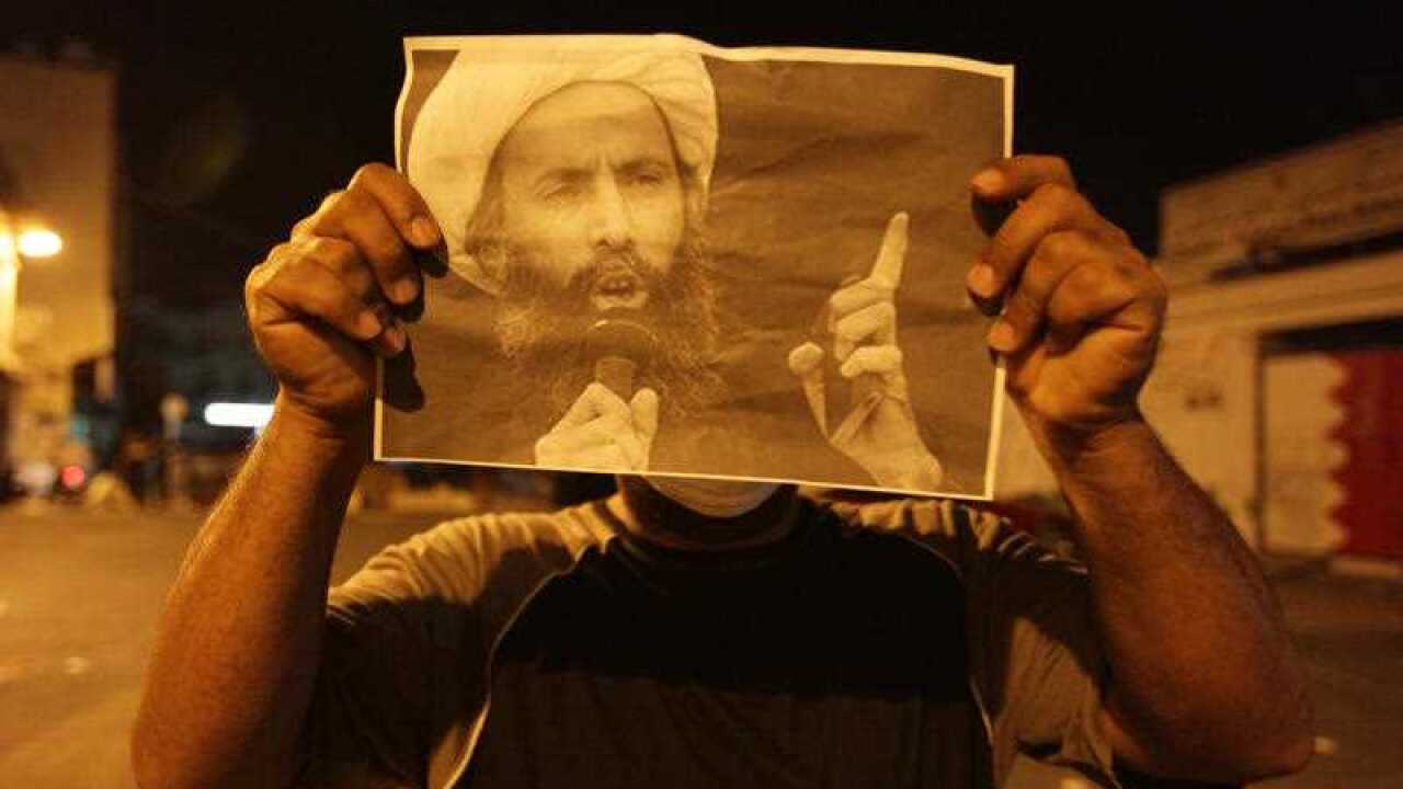 n this Wednesday, Oct. 15, 2014, file photo, a Bahraini anti-government protester holds up a picture of jailed Saudi Sheik Nimr al-Nimr during clashes with riot police in Sanabis, Bahrain, a suburb of the capital Manama. (AP)