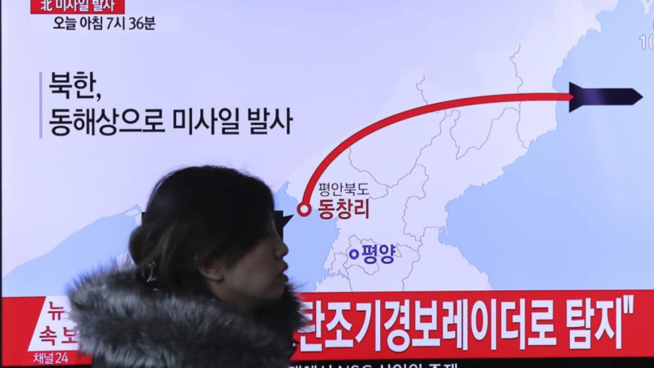 A TV screen shows a news report about the North Korean missile launch