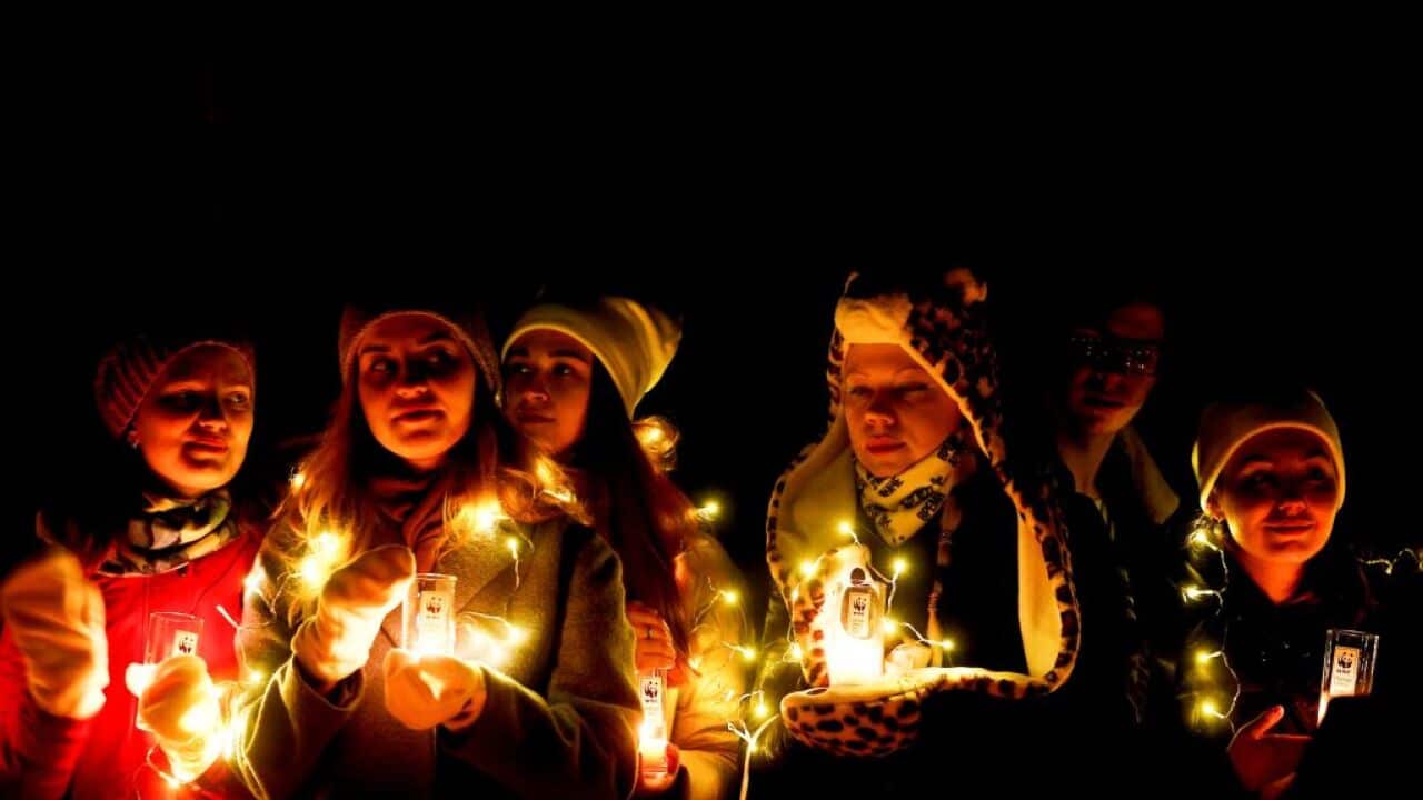 Activists light candles as they gather at Red Square.