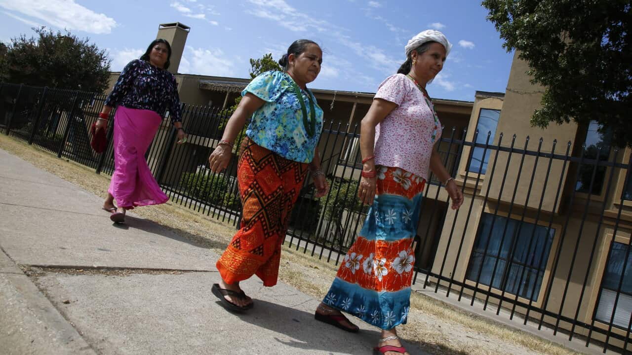Three women walk near the Ivy Apartments is under guard in Dallas (Nathan Hunsinger/Dallas Morning News/MCT)
