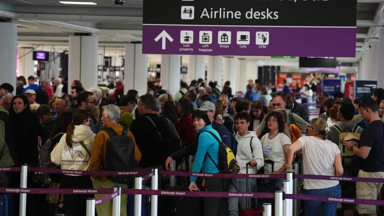 Passengers in a long queue at Edinburgh Airport.