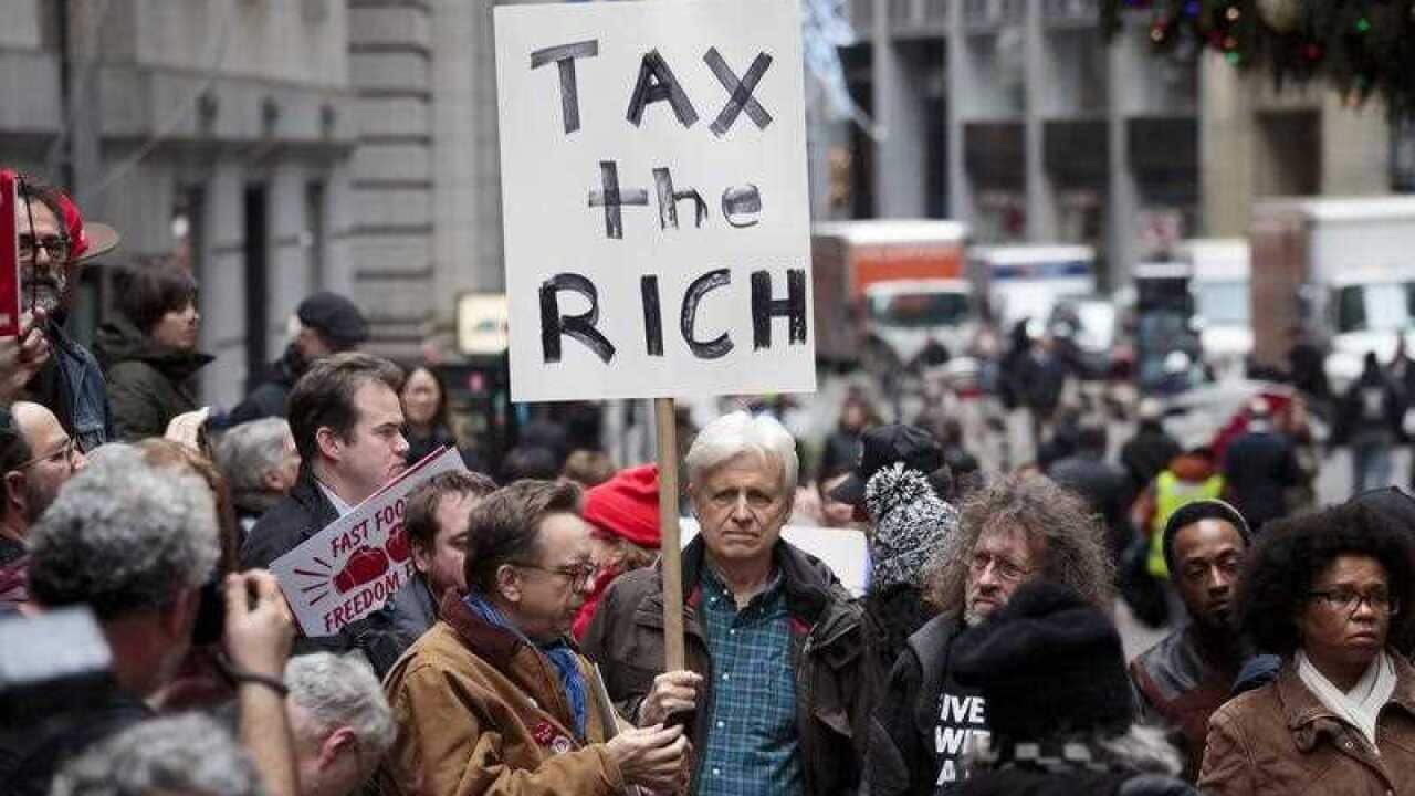 People gather to protest new tax legislation that is close to being passed by the United States Congress in front of the New York Stock Exchange in New York, New York, USA, 19 December 2017.