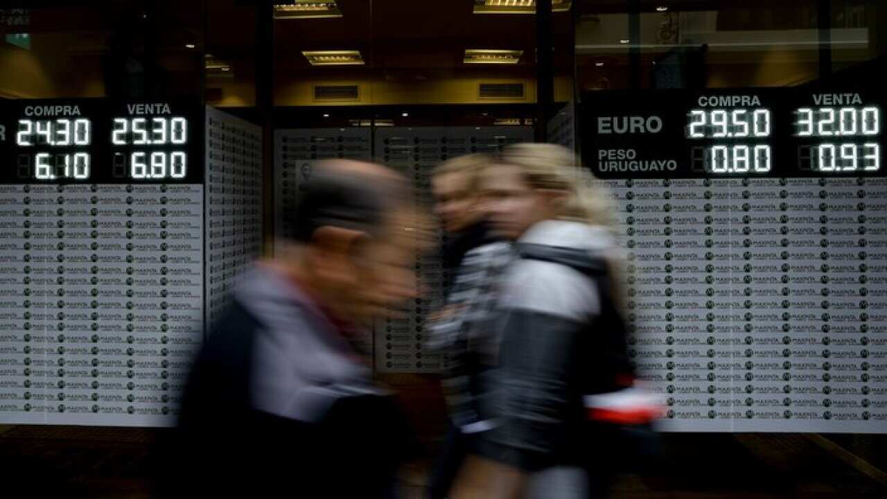 People walk by a money exchange house
