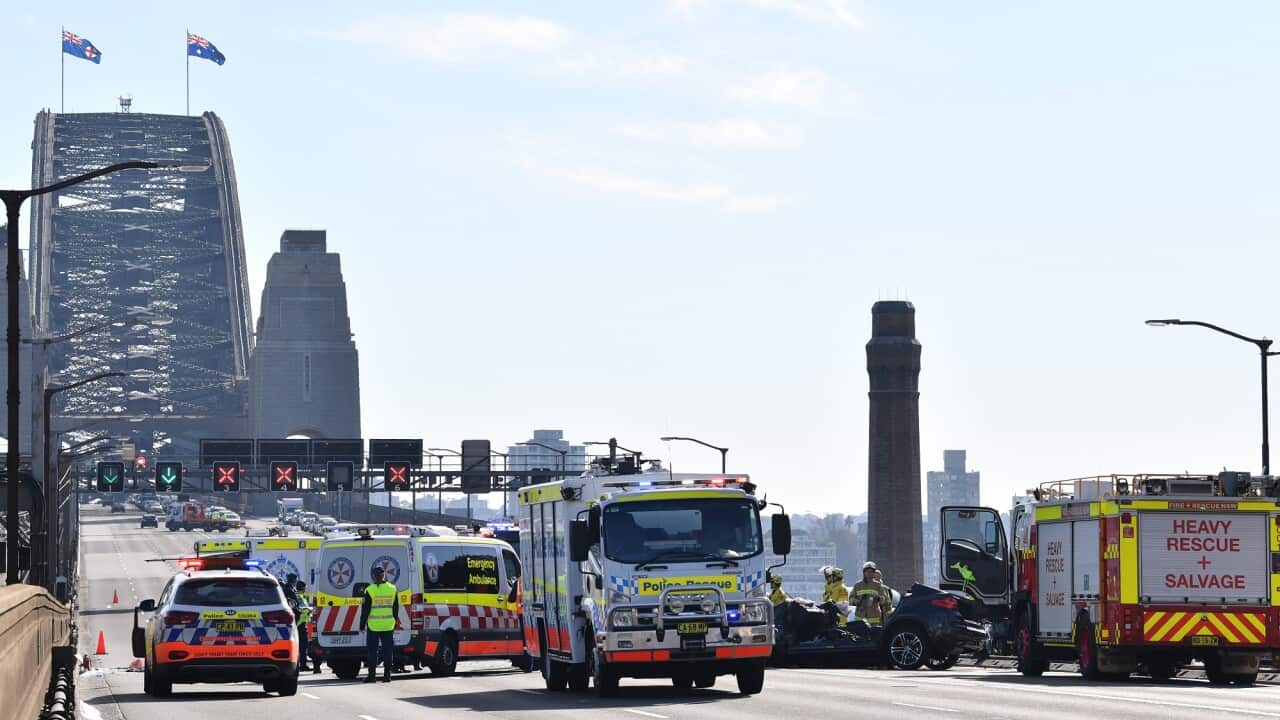 Police vehicles, ambulances and fire trucks are parked at the scene of a fatal crash on the Sydney Harbour Bridge.