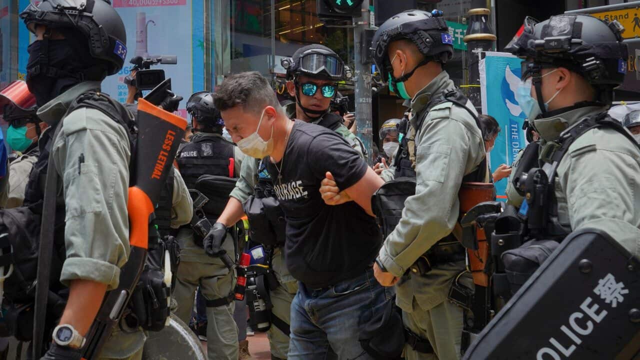Police detain a protester after spraying pepper spray during a protest before the annual handover march in Hong Kong.