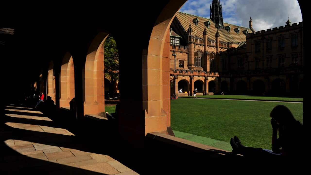 Students sit next to The Quadrangle at The University of Sydney, in Sydney.