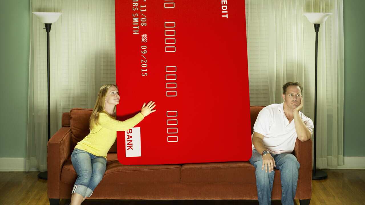 Woman & man & oversized credit card on couch