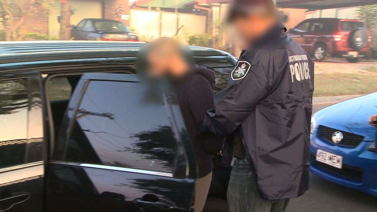 Supplied image obtained Wednesday, Sept. 10, 2014 of Australian Federal Police officers during an operation in Brisbane. Two Queensland men will be charged with preparing to send fighters to join the conflict in Syria after a year-long counter-terrorism i