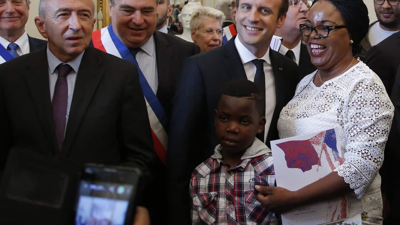 French President Emmanuel Macron, poses with new French citizens during a citizenship ceremony.