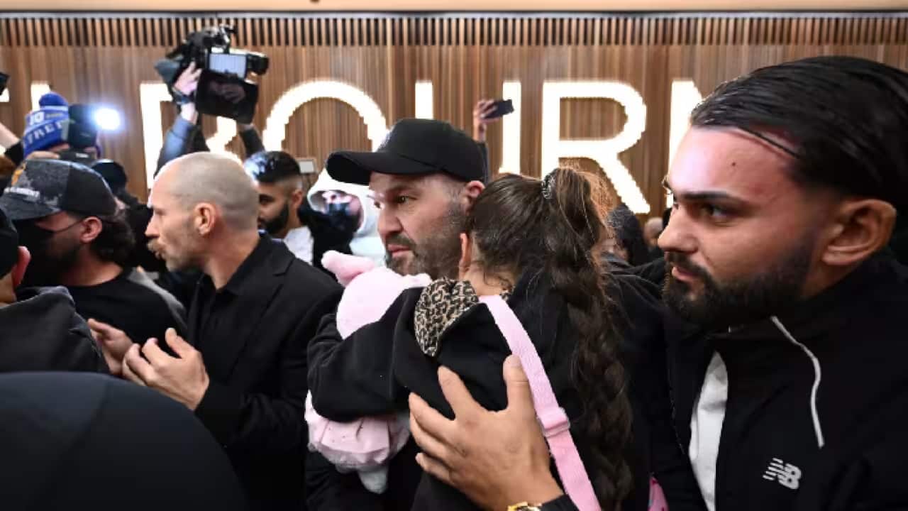 أقارب يحيطون بإحدى العائلات المرتبطة بداعش لدى وصولها إلى مطار ملبورن الدولي بعد عودتها من مخيم احتجاز في سوريا..png