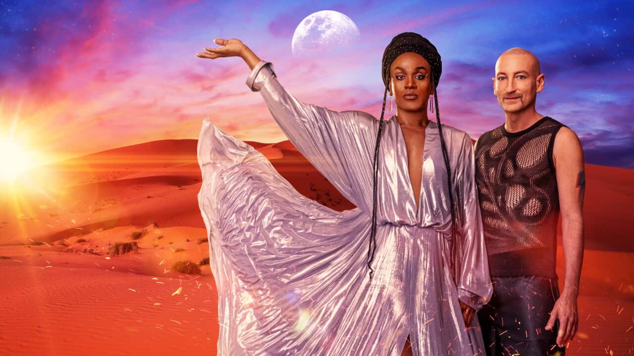 Electric Fields stand in a desert the sun is setting and the moon is rising