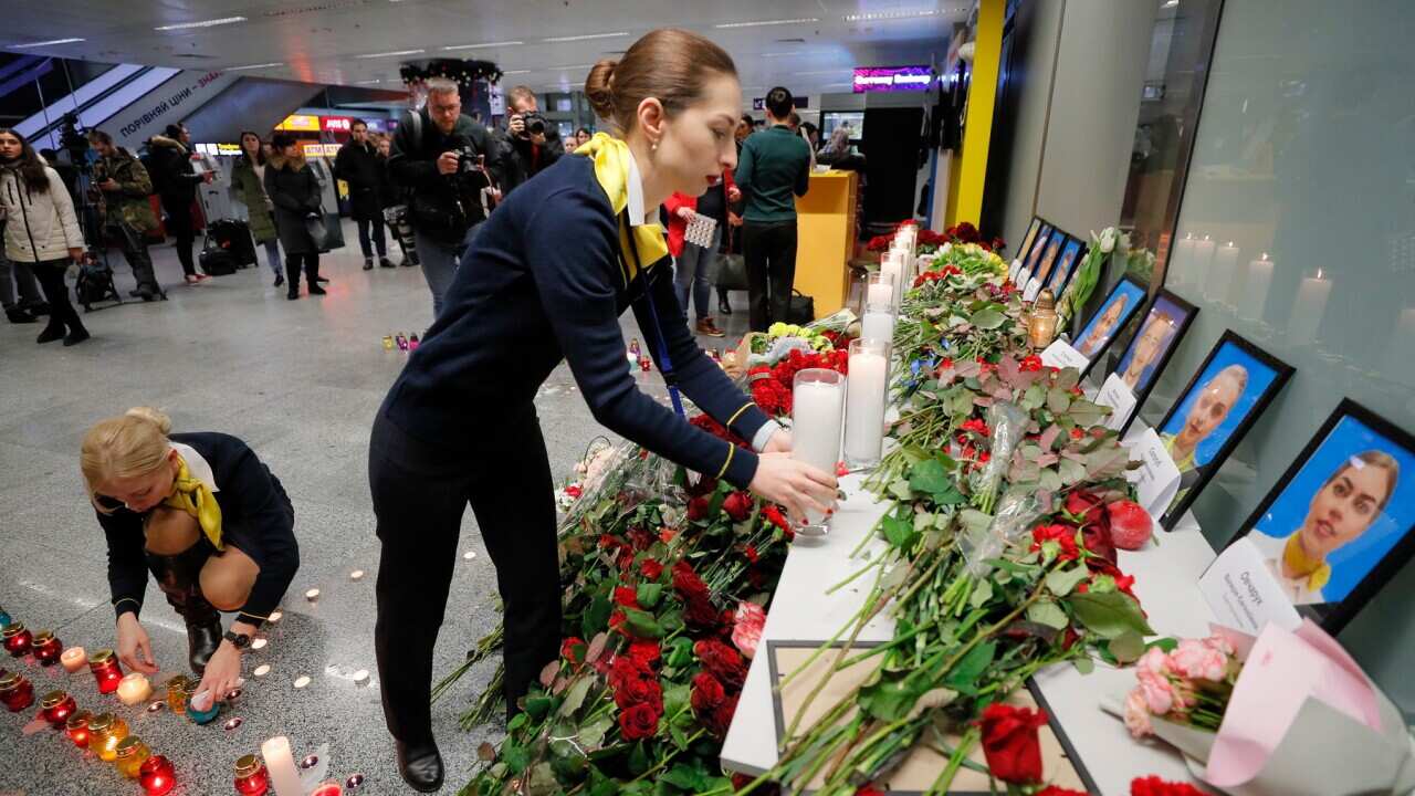 Friends and family of crew members of the crashed Ukraine International Airlines Flight lay tributes at the airport in Kyiv (AAP)