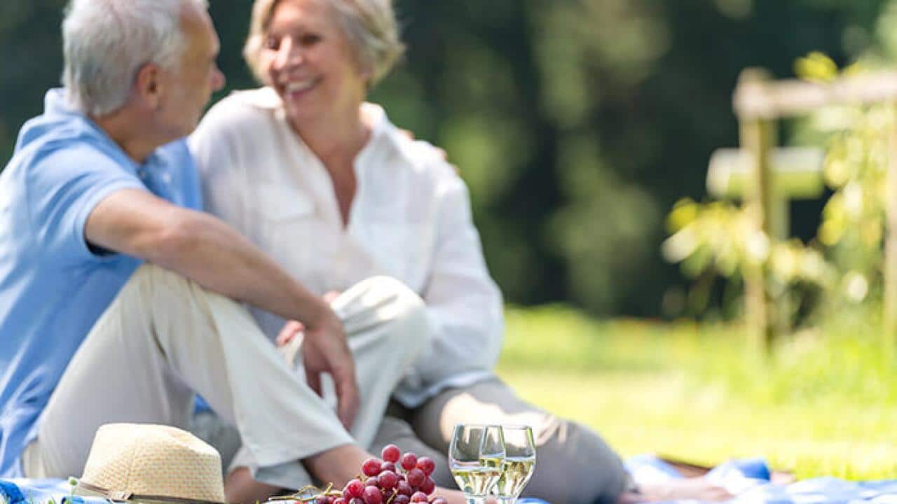 Senior couple picnicking in the park smiling---Senior couple picnicking in the park smiling (CTK via AP Images)