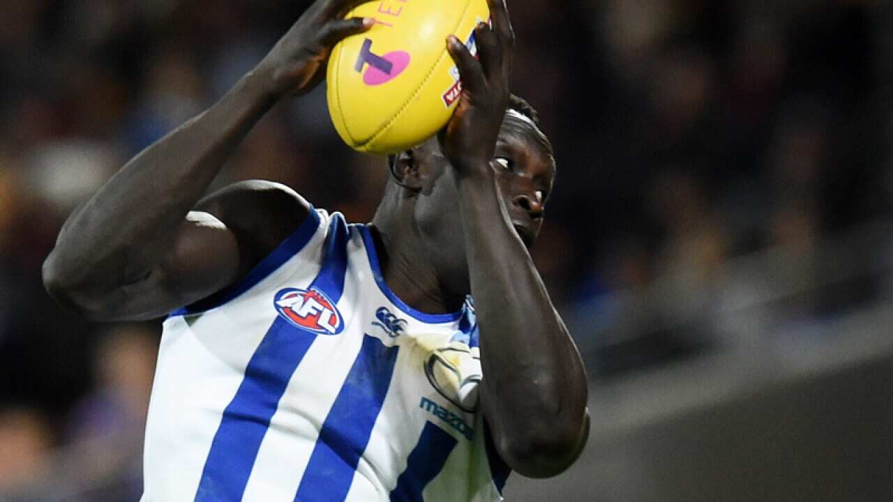 Majak Daw of the Kangaroos takes a mark to score a goal