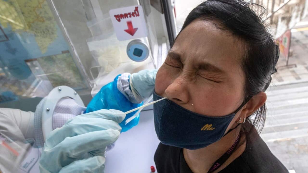 A health worker collects a nasal swab from a woman for a coronavirus test in Rayong, Thailand (AAP image - EPA - VIBCENT GAUTER)