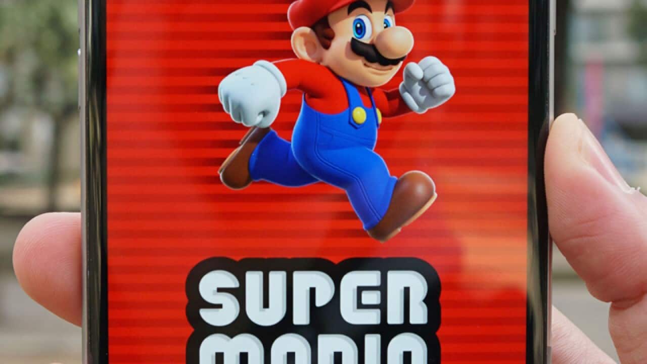A smartphone displays the start screen of Super Mario Run