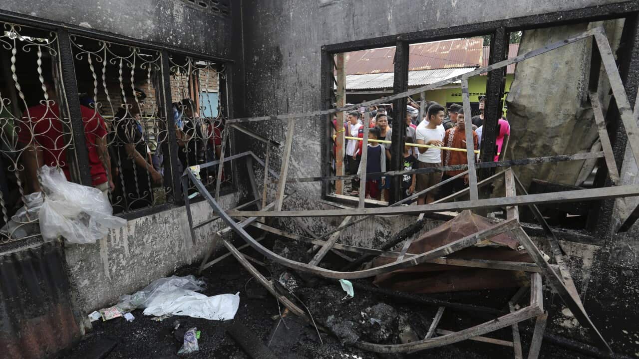 Residents examine the damage after a fire razed through a match factory in Langkat, North Sumatra, Indonesia, Friday, June 21, 2019.