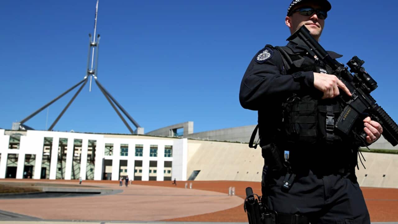 Federal police patrol the front of Parliament House