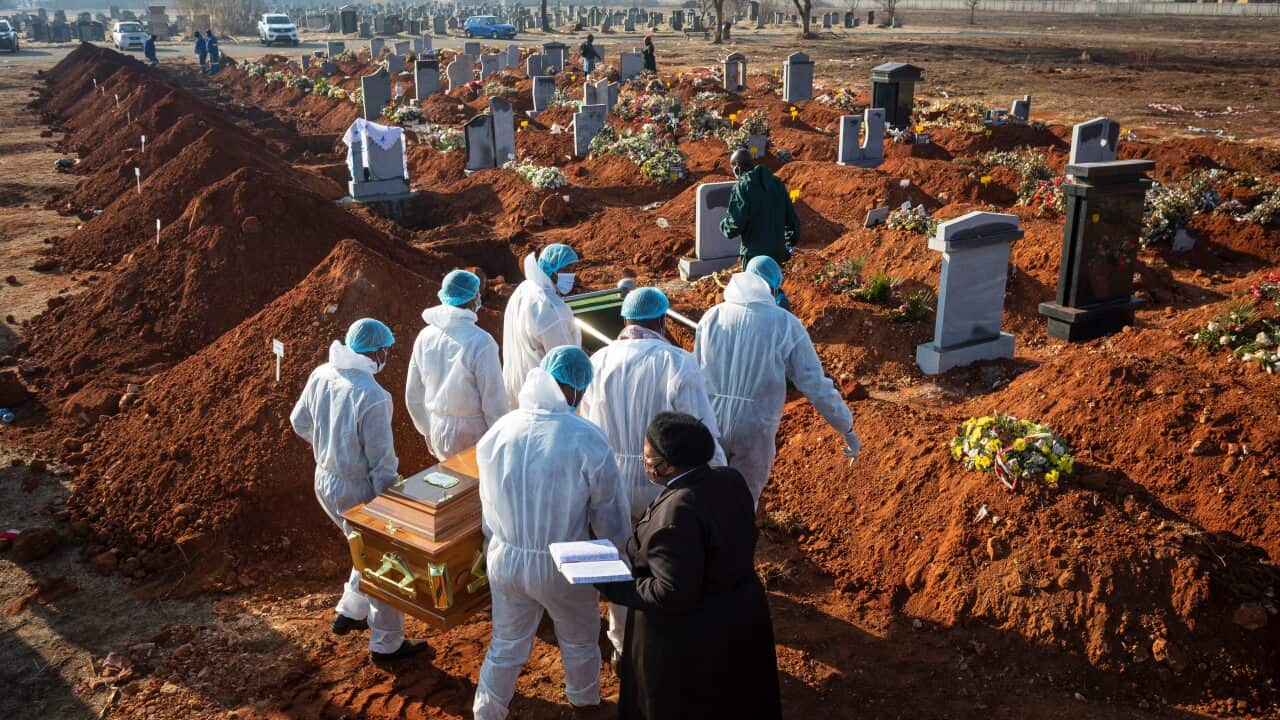 Family members wearing full PPE suits carry the remains of their elderly family member who died of COVID-19 in Johannesburg, South Africa.