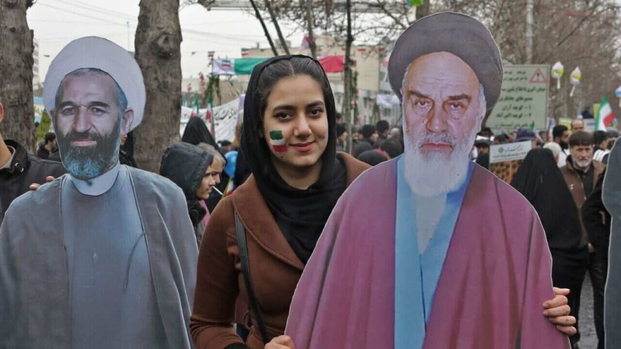 An Iranian woman poses with a life-size cutout portrait of Islamic Revolution founder Ayatollah Ruhollah Khomeini.