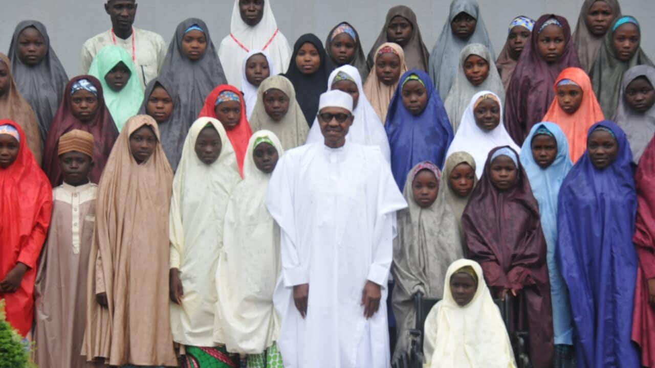 President Muhammadu Buhari (C) poses for photographs with the released Dapchi School Girls who were abducted by Boko Haram