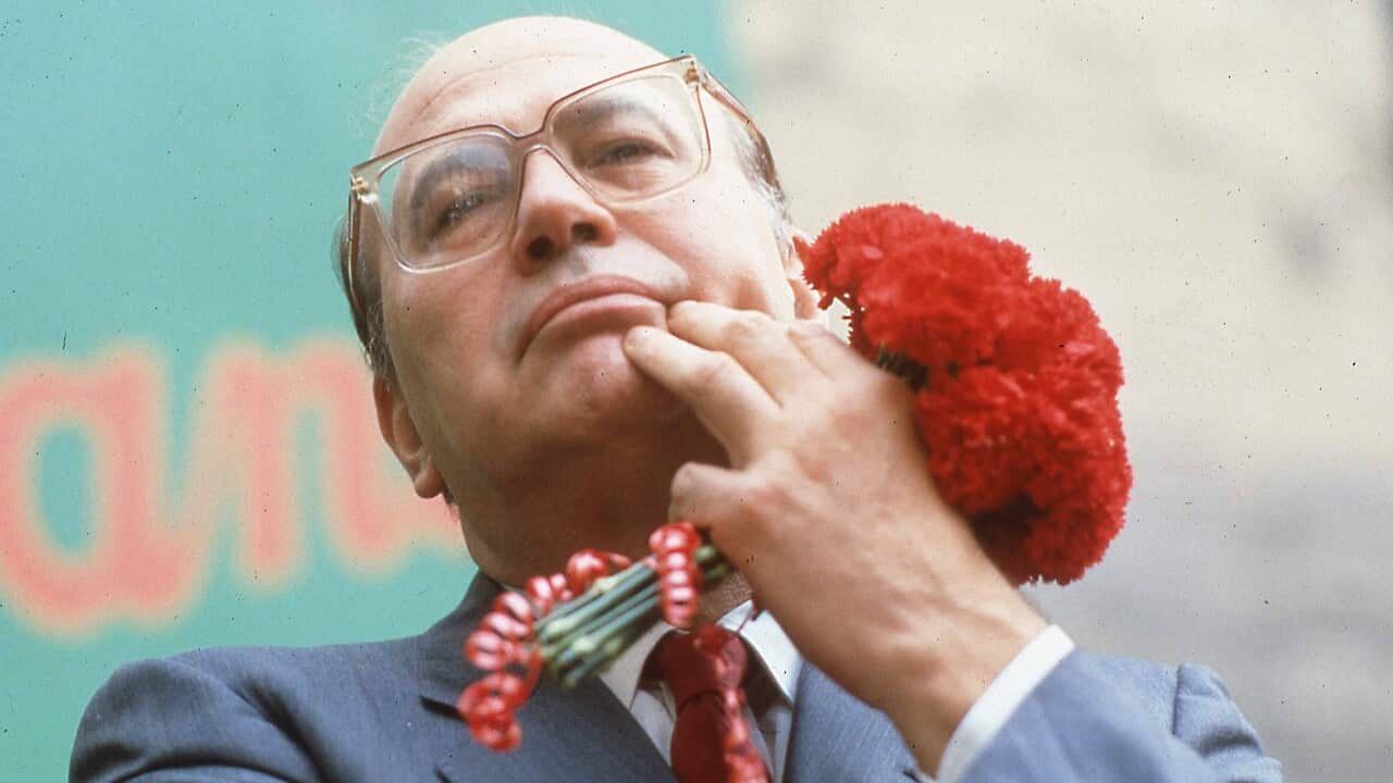 Il leader del Partito Socialista Bettino Craxi, ritratto con il tradizionale garofano rosso simbolo del partito durante la campagna elettorale del 1987.