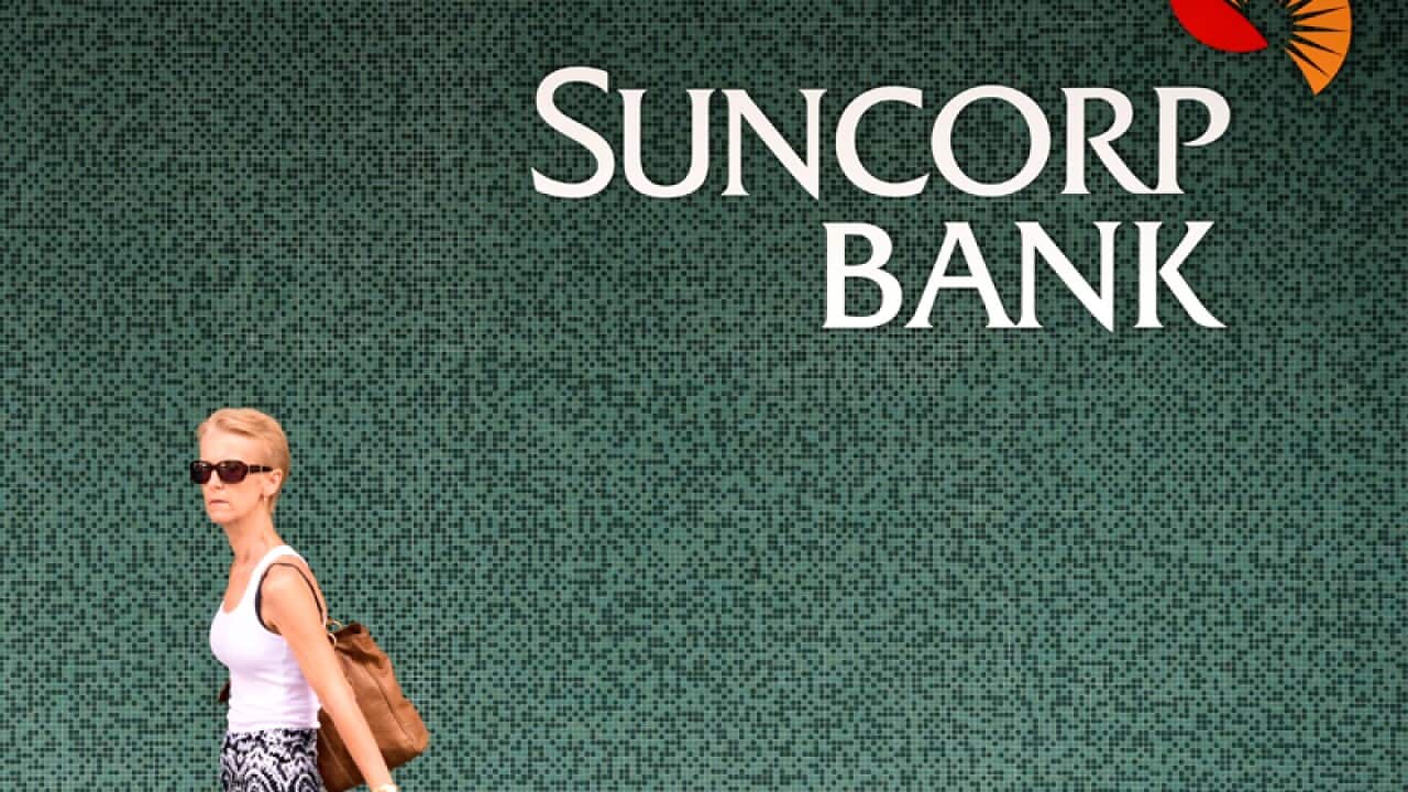 A woman walks past a Suncorp Bank branch
