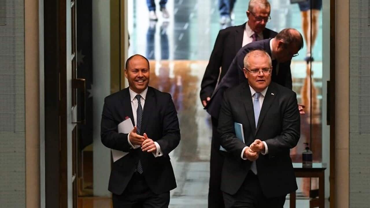 Prime Minister Scott Morrison (R) and Treasurer Josh Frydenberg (L) attend a parliamentary sitting.