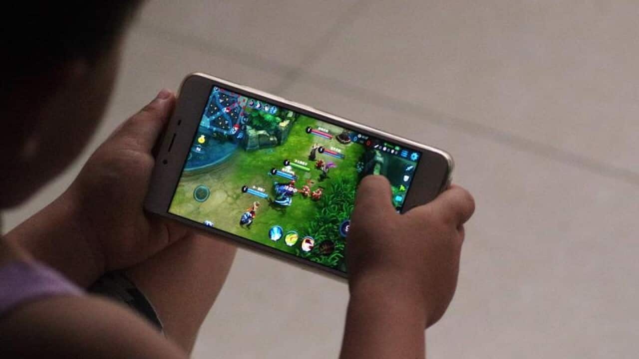 A young child plays a mobile game.