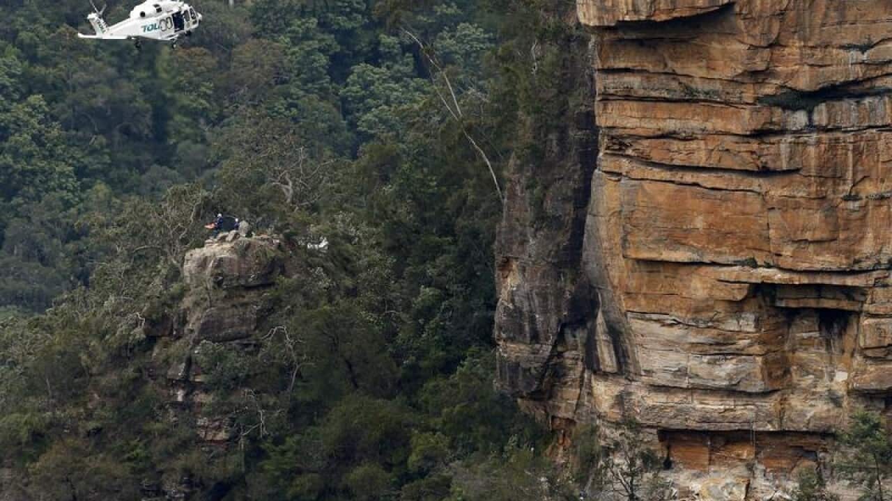 A man is winched into a rescue helicopter near Wentworth Falls