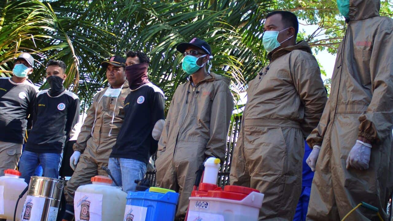 Healthcare Volunteers spray disinfectants in Blangpidie, Indonesia