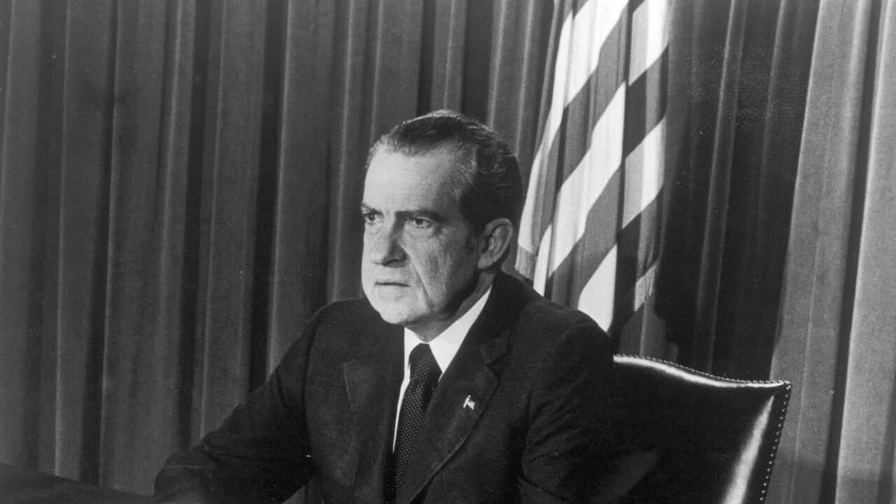 U.S. President Richard M. Nixon sits at a desk as he announces his resignation on television