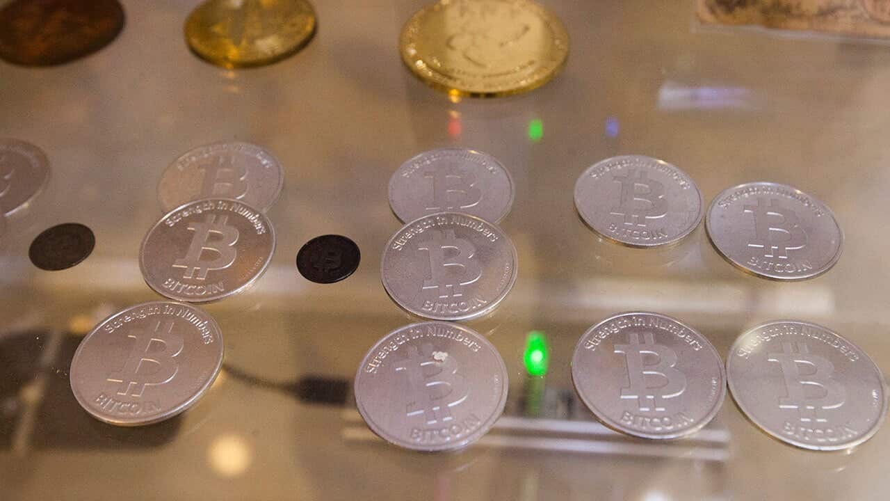 Commemorative souvenir mock bitcoins are displayed in a 'Bitcoin Museum'.