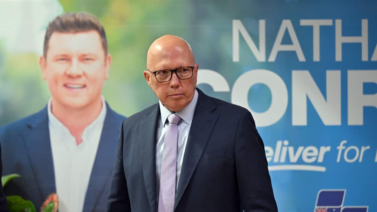 Peter Dutton walks in front of a Liberal party backdrop