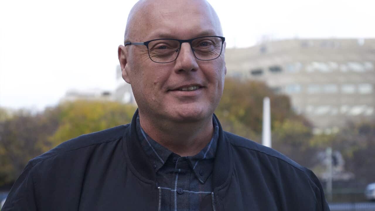 A man wearing glasses smiling.