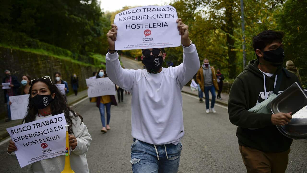 People hold up banners that read 'I search for work', in Pamplona, Spain