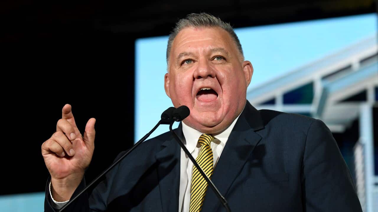 A man speaks with his finger raised.