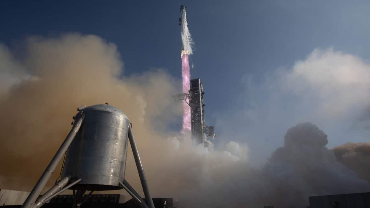 Rocket launching from a test pad through clouds of smoke and steam.
