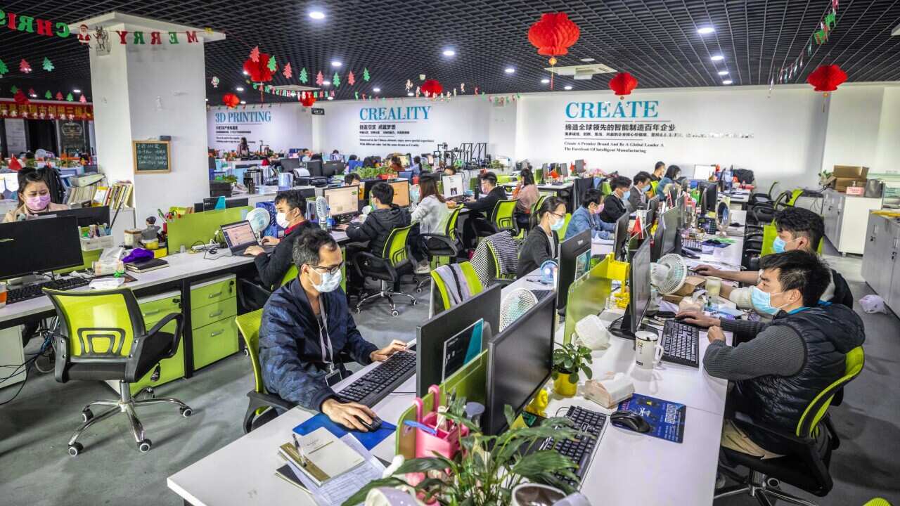 Staff wearing protective masks work in an office at Creality 3D in Shenzhen, Guangdong province, China.