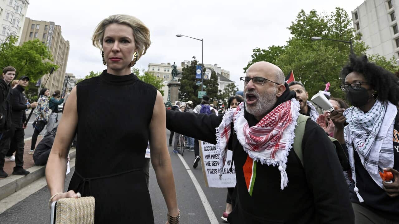 A male protester shouts as a woman walks past